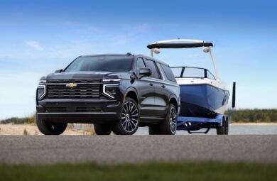 Front 3/4 shot of the 2025 Suburban High Country towing a boat