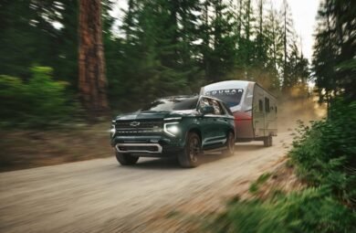 Front 3/4 angle in motion of 2025 Chevrolet Tahoe Z71 in Cypress Gray trailering.